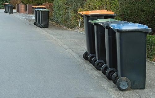 Tonnen mit Griff zur Straße Vier Tonnen stehen zur Abholung an der Straße bereit.