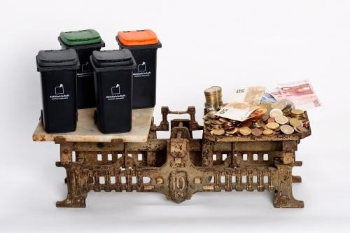 Gebührenwaage Gebührenwaage mit Mülltonnen links und Geld rechts.