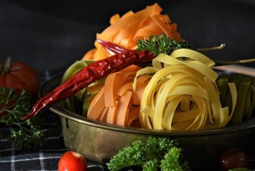 Bunte Nudeln in Topf mit Chilischote und Petersilie